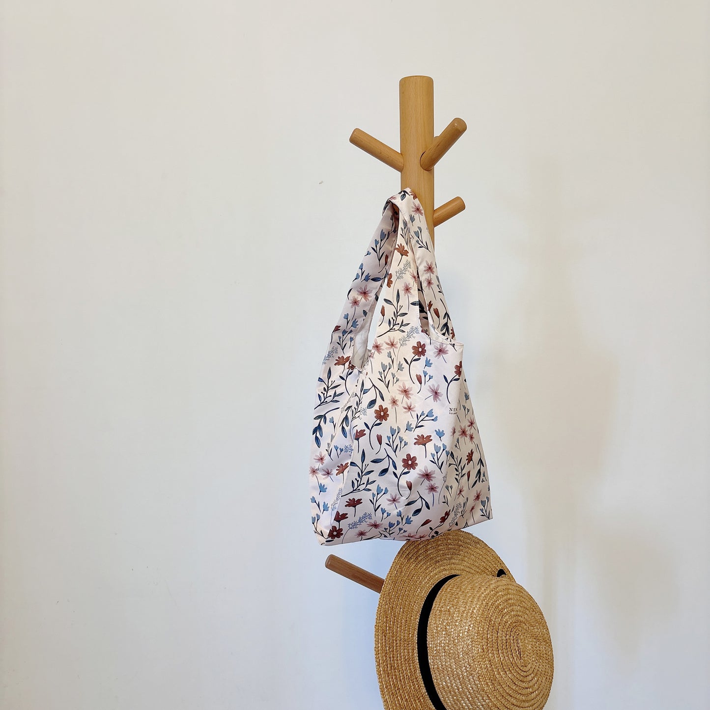 Wild Flower reusable bag hanging on a rack, showcasing its elegant design and fabric texture.