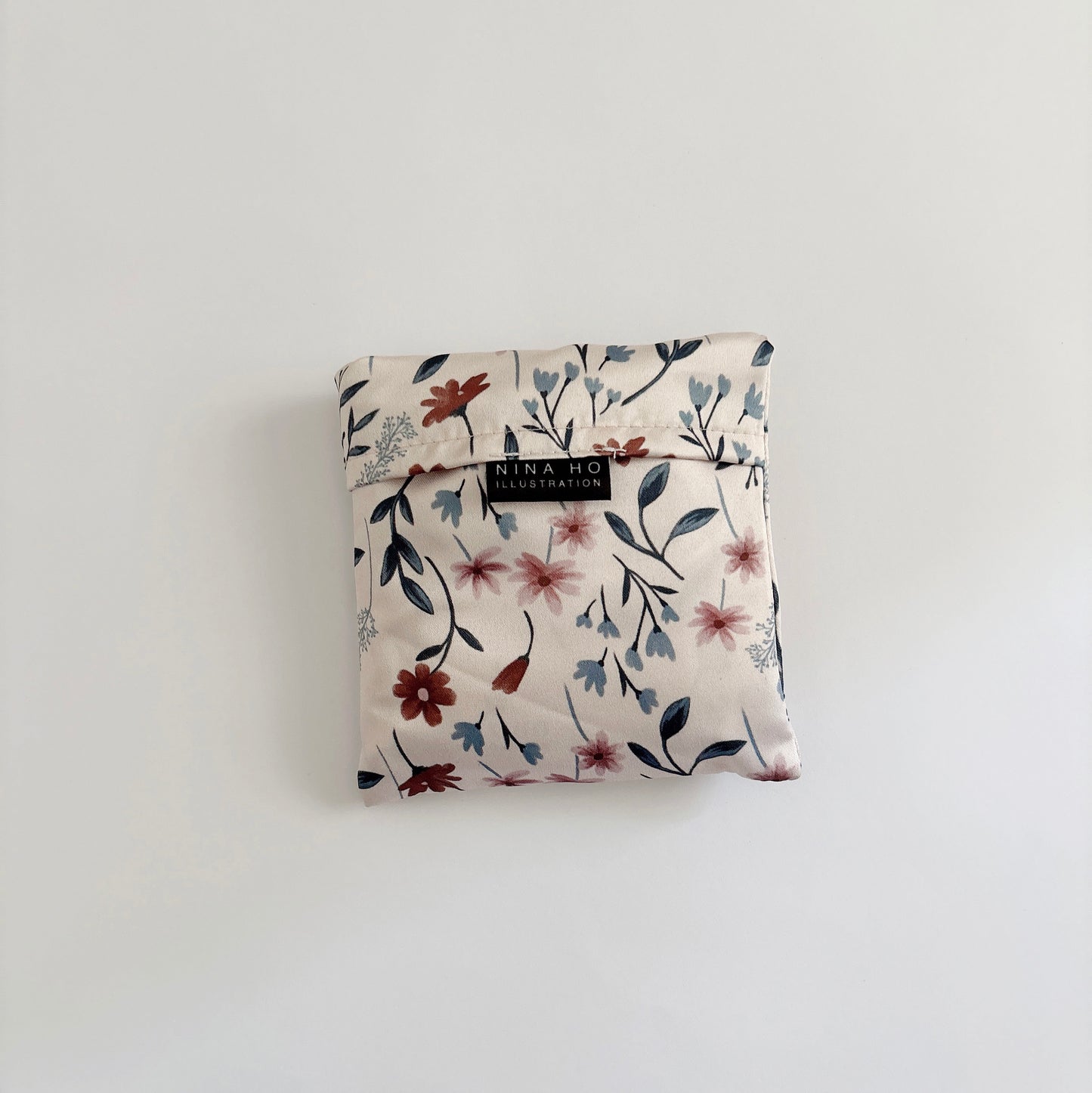 The Wild Flower reusable bag, folded neatly, showcases its charming and elegant design.